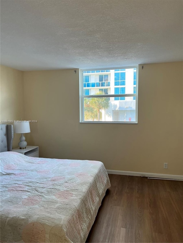 bedroom featuring hardwood / wood-style flooring and a textured ceiling