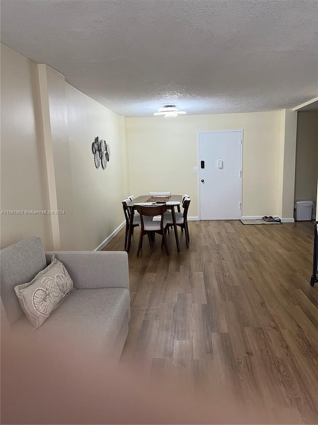 dining space with hardwood / wood-style flooring and a textured ceiling