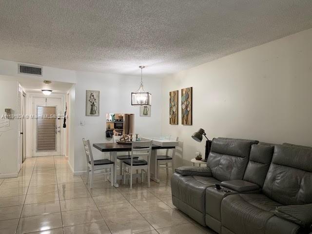 living room with a textured ceiling and light tile floors