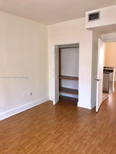 unfurnished bedroom featuring hardwood / wood-style floors and a closet