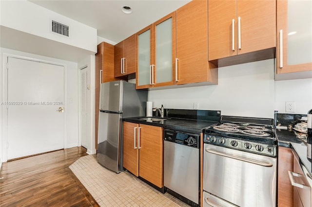 kitchen featuring stainless steel appliances, light hardwood / wood-style floors, and sink