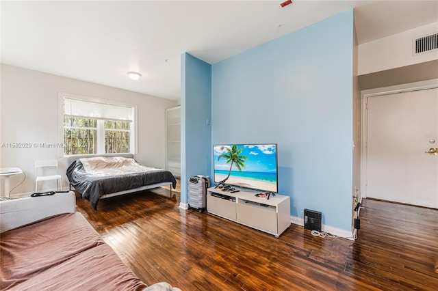 bedroom with dark hardwood / wood-style flooring