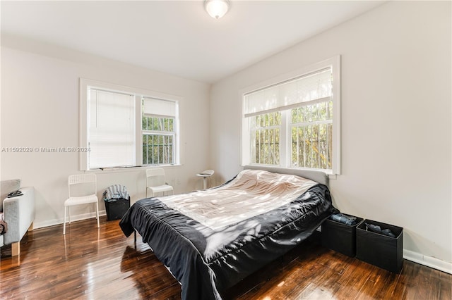 bedroom with dark hardwood / wood-style flooring