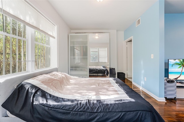 bedroom with dark hardwood / wood-style floors