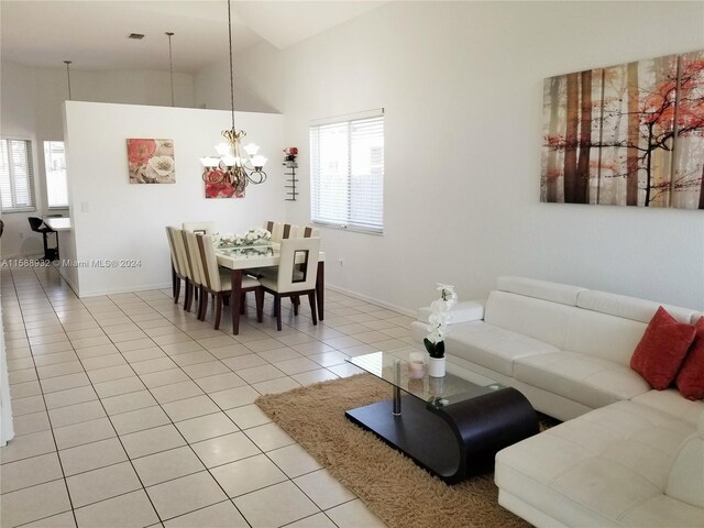 living room with a notable chandelier, light tile patterned floors, and high vaulted ceiling