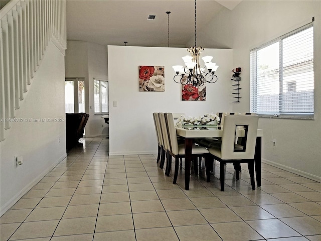 tiled dining space with high vaulted ceiling and a chandelier