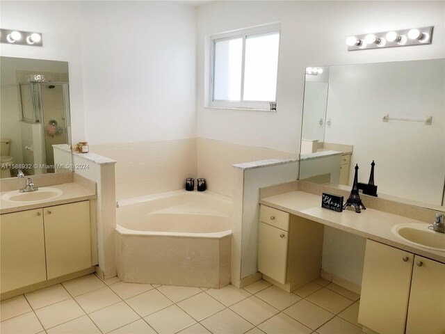 bathroom with vanity, tile patterned floors, and a bath