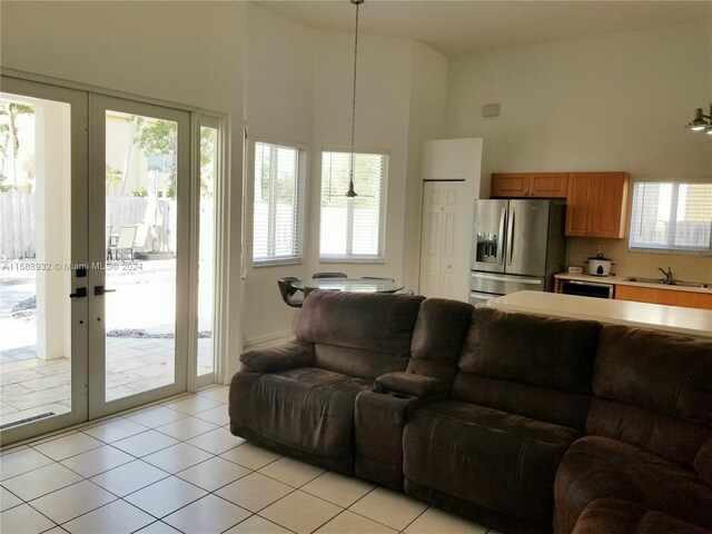 living room featuring sink, a healthy amount of sunlight, and light tile patterned floors