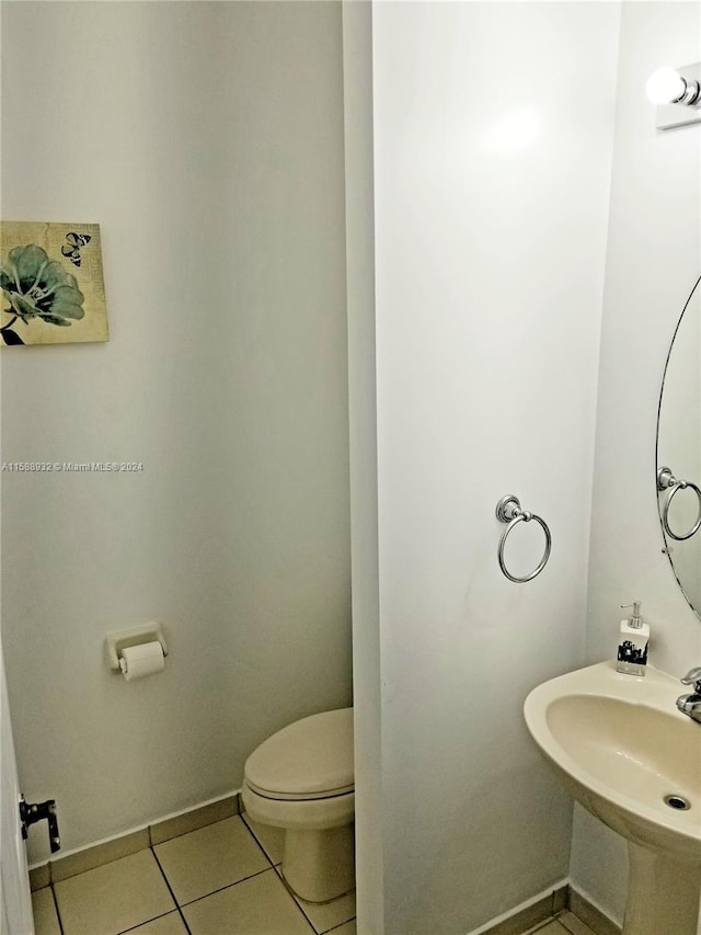 bathroom featuring tile patterned flooring, toilet, and sink