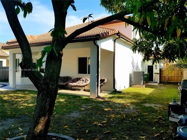 rear view of house featuring a patio and a yard