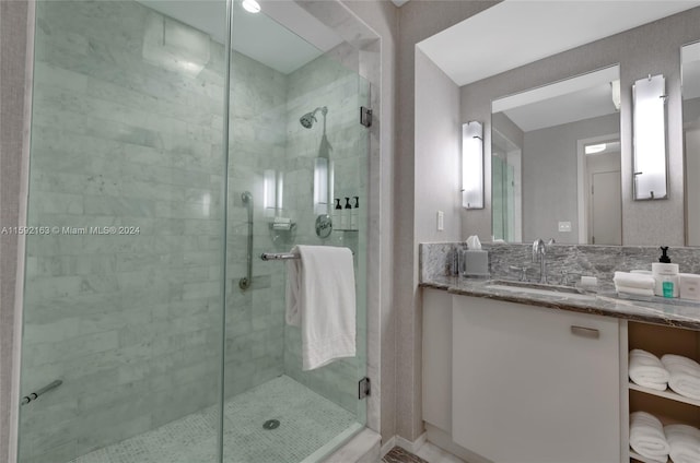 bathroom with a shower with shower door and vanity