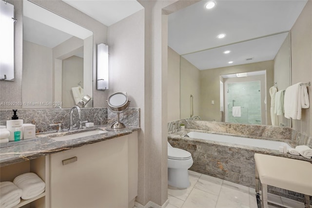 bathroom featuring tile floors, a relaxing tiled bath, vanity, and toilet