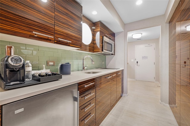 kitchen with sink, tasteful backsplash, light tile floors, and stainless steel microwave