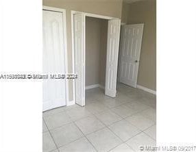 unfurnished bedroom featuring a closet and light tile floors