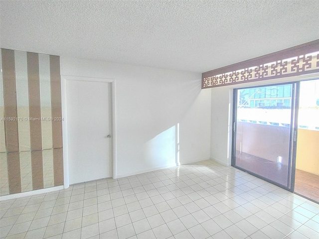 tiled empty room with a textured ceiling