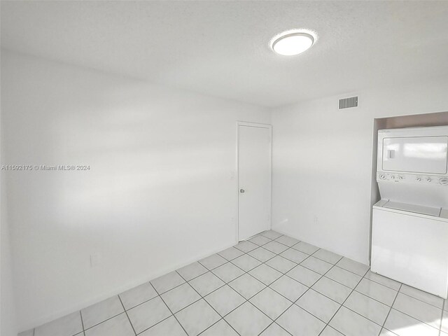 spare room with light tile patterned flooring and a textured ceiling