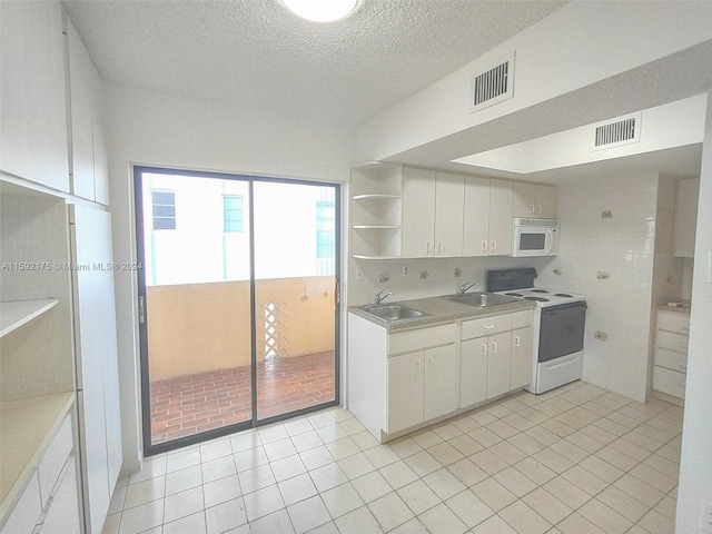 kitchen featuring white cabinetry, sink, white appliances, and light tile patterned floors