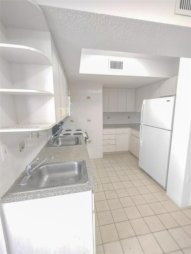 kitchen featuring white cabinetry, sink, white appliances, and a textured ceiling