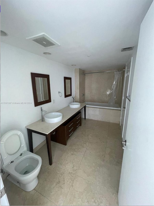 bathroom with toilet, tile patterned flooring, and double sink vanity