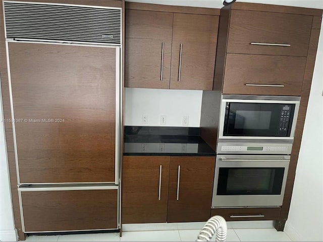 kitchen with built in appliances and light tile patterned floors