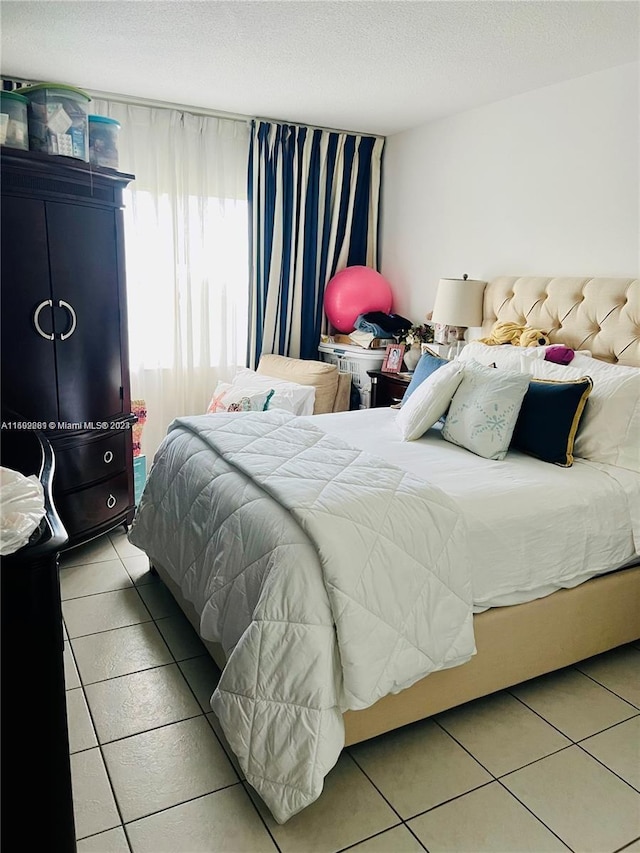 tiled bedroom featuring a textured ceiling