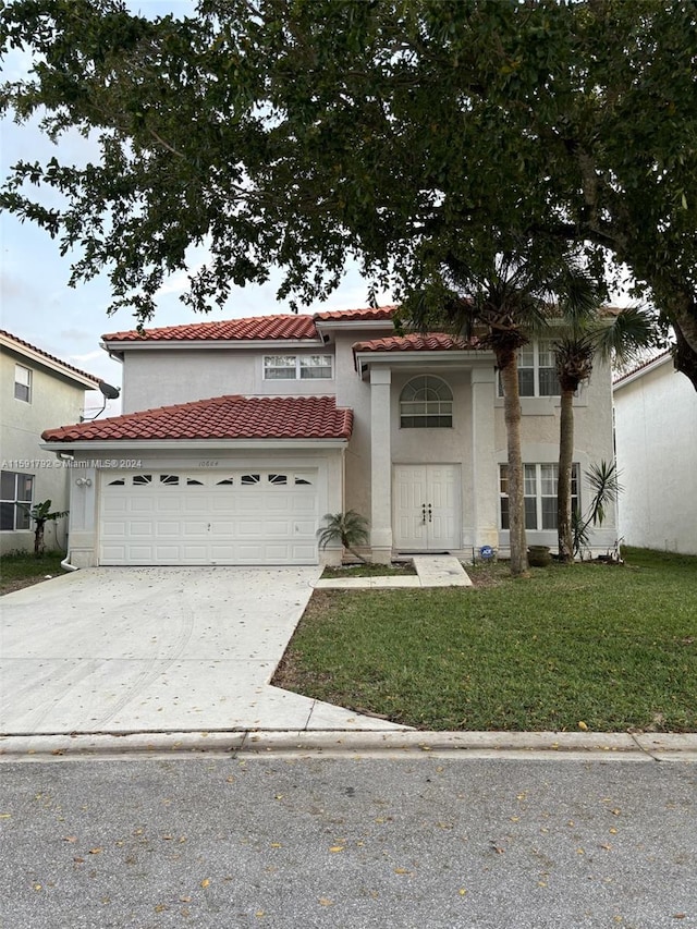 mediterranean / spanish house with a garage and a front yard