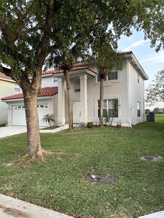 view of front of home featuring a garage, a front yard, and central AC unit