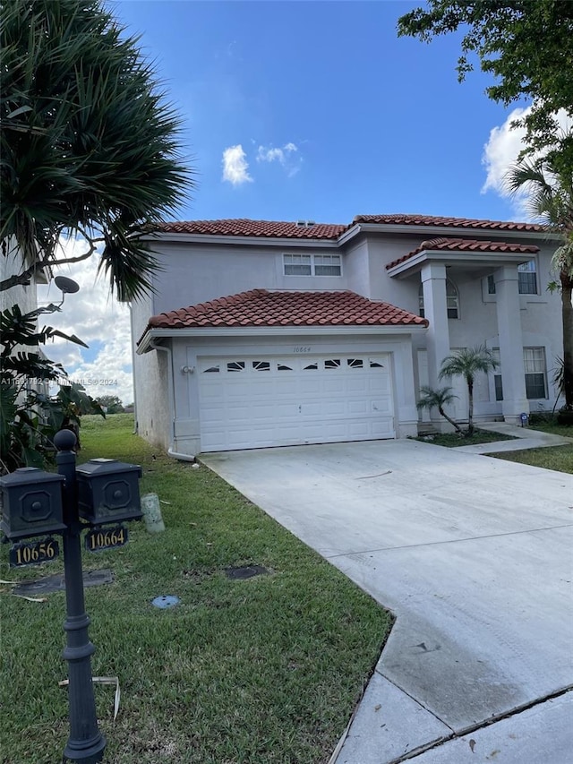 mediterranean / spanish house with a garage and a front lawn