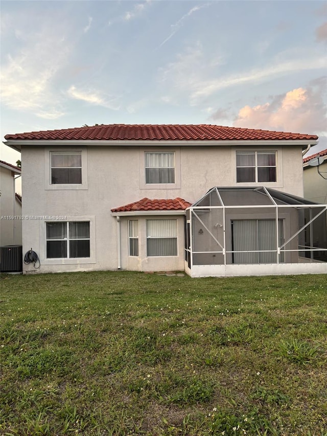 back of property with a yard and central AC unit