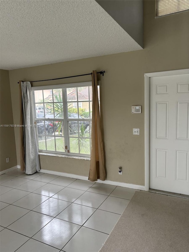 foyer entrance featuring tile floors and a textured ceiling