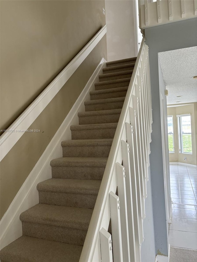 stairs with tile flooring and a textured ceiling