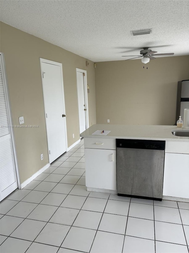 kitchen featuring a textured ceiling, stainless steel dishwasher, white cabinets, light tile flooring, and ceiling fan