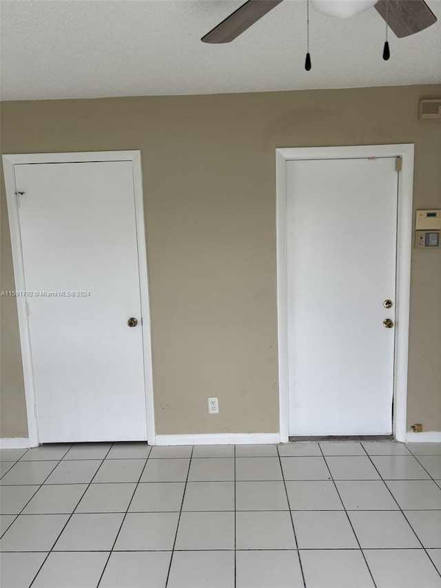 tiled spare room featuring ceiling fan and a textured ceiling