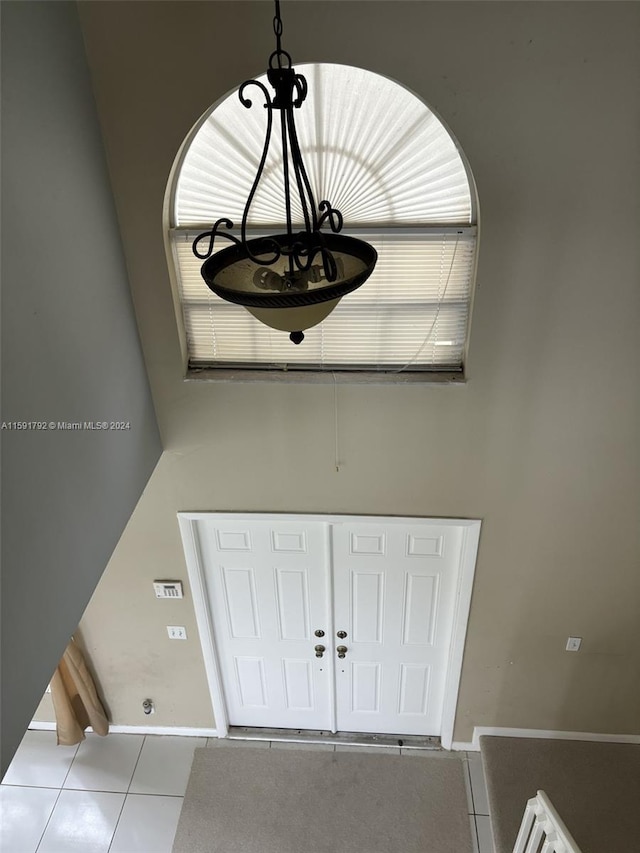 interior details with tile floors and a chandelier