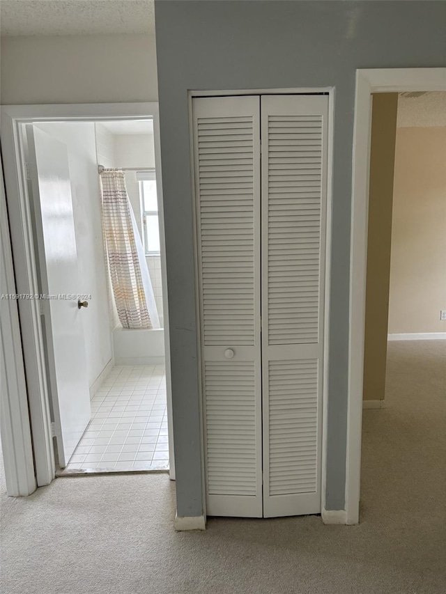 hallway with carpet floors and a textured ceiling