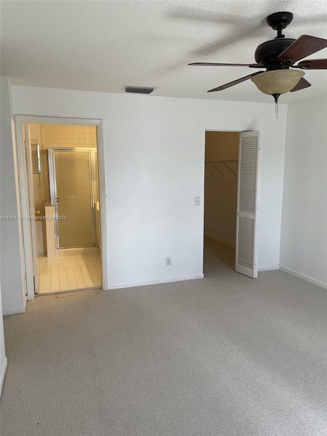 carpeted spare room with ceiling fan and a textured ceiling