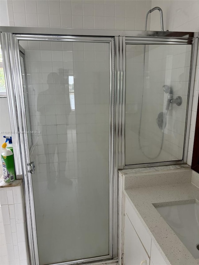 bathroom featuring an enclosed shower and vanity