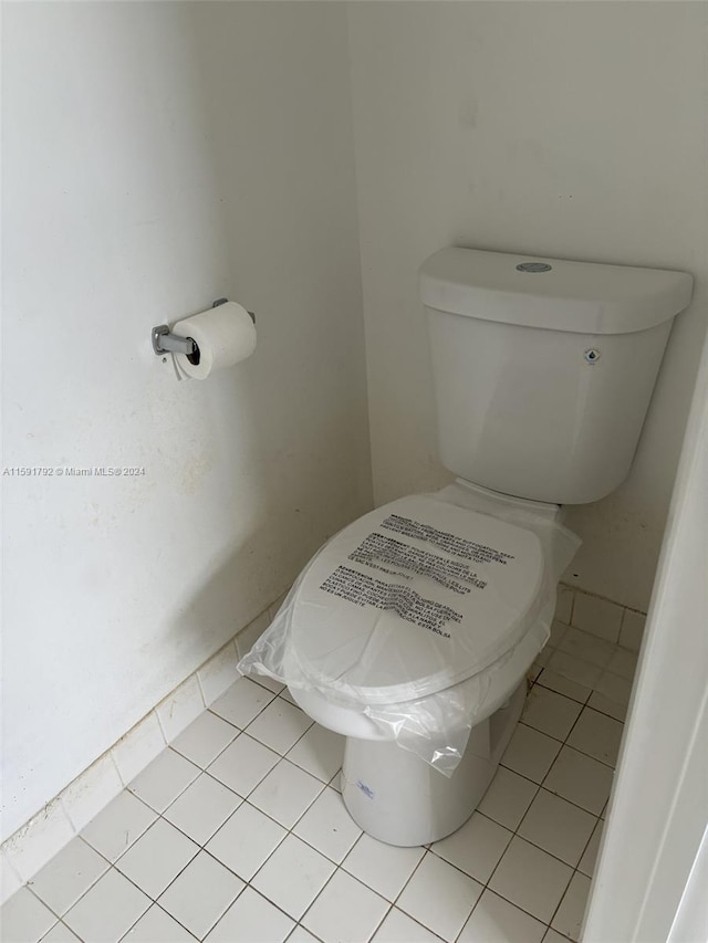 bathroom featuring tile flooring and toilet