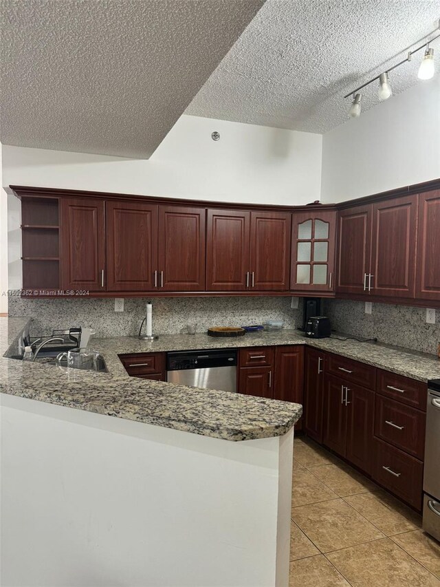 kitchen with kitchen peninsula, tasteful backsplash, dishwasher, a textured ceiling, and light tile floors