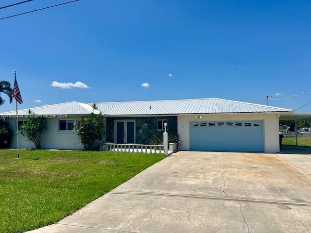 single story home with a garage and a front lawn