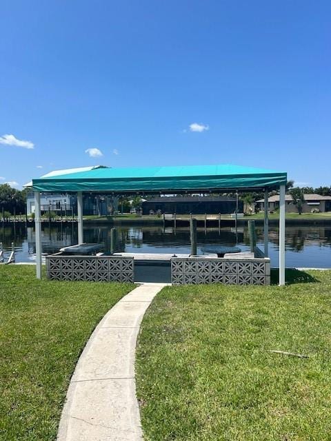 view of dock with a yard and a water view