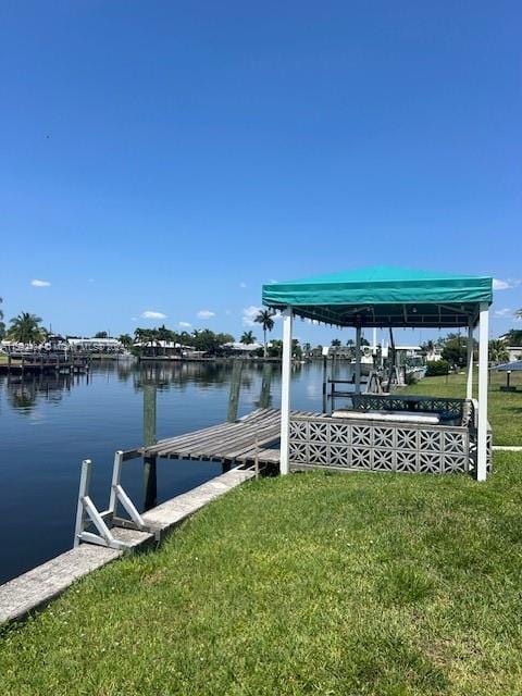 dock area with a water view and a yard