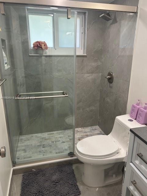 bathroom featuring tile floors, walk in shower, vanity, and toilet