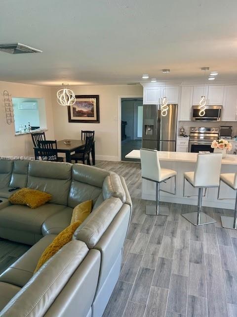 living room featuring an inviting chandelier and light hardwood / wood-style flooring