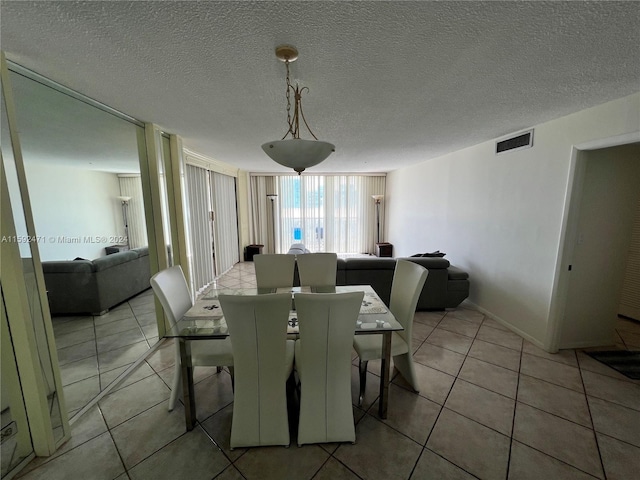 tiled dining space with a textured ceiling