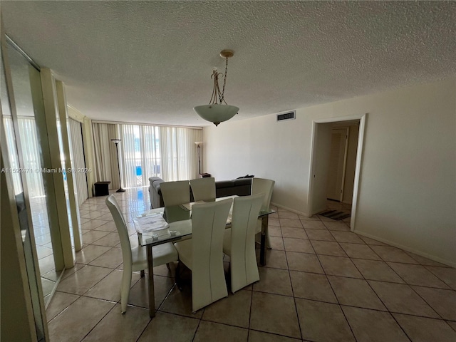 dining space with floor to ceiling windows, tile flooring, and a textured ceiling