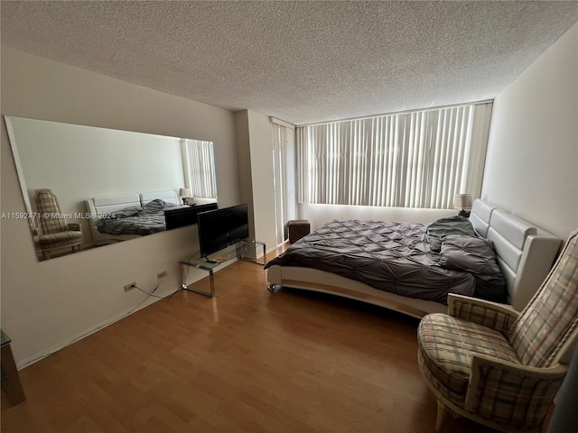 bedroom featuring wood-type flooring and a textured ceiling