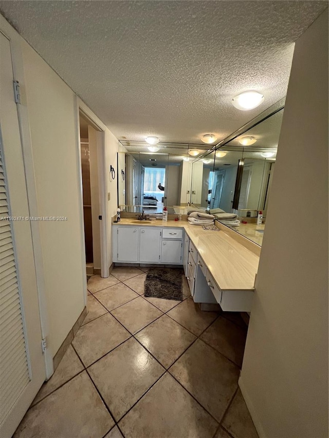 bathroom with tile floors, a textured ceiling, and oversized vanity