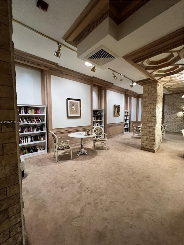 unfurnished room featuring brick wall, carpet, and rail lighting