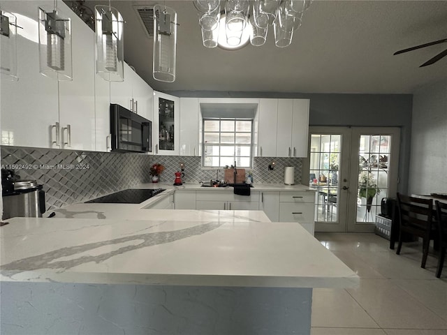 kitchen with ceiling fan with notable chandelier, white cabinets, tasteful backsplash, and stove